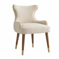 Silla tapizada en lino beige con patas de madera y detalles metálicos